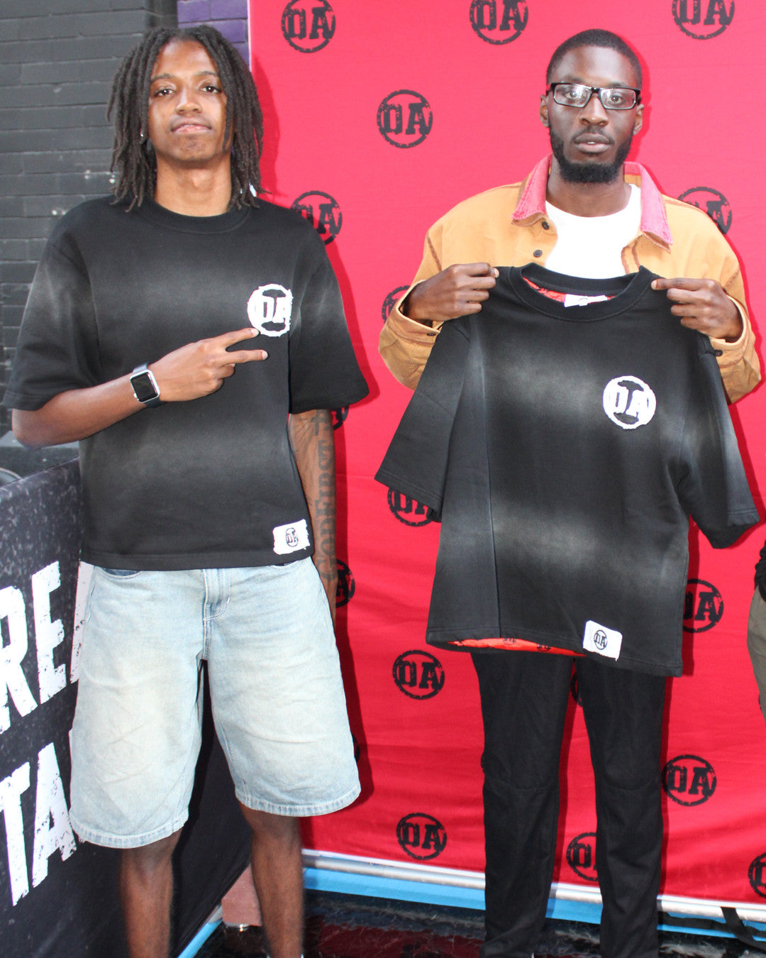 A customer holding up the Origin Blank tee next to OA's founder