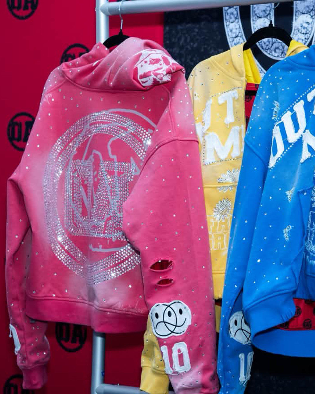 OUT THE MUD hoodies in pink, yellow and blue on the rack