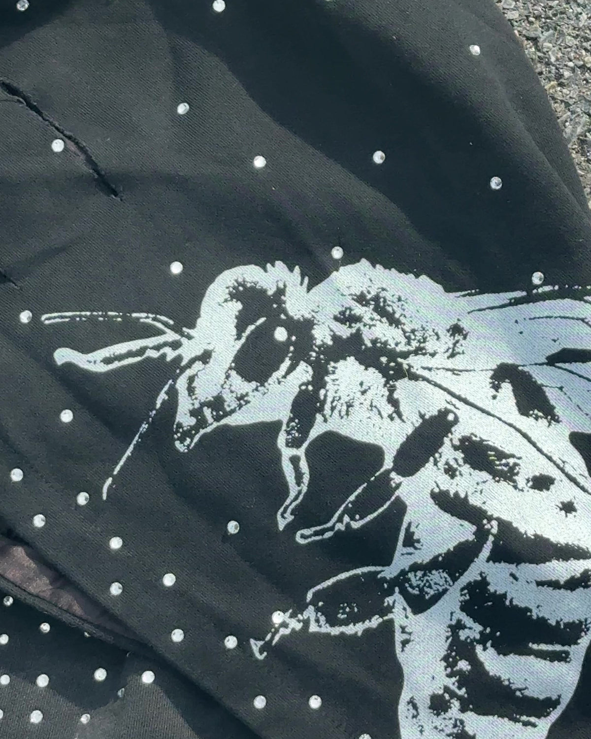 Close-up of the bee print on the OUT THE MUD hood