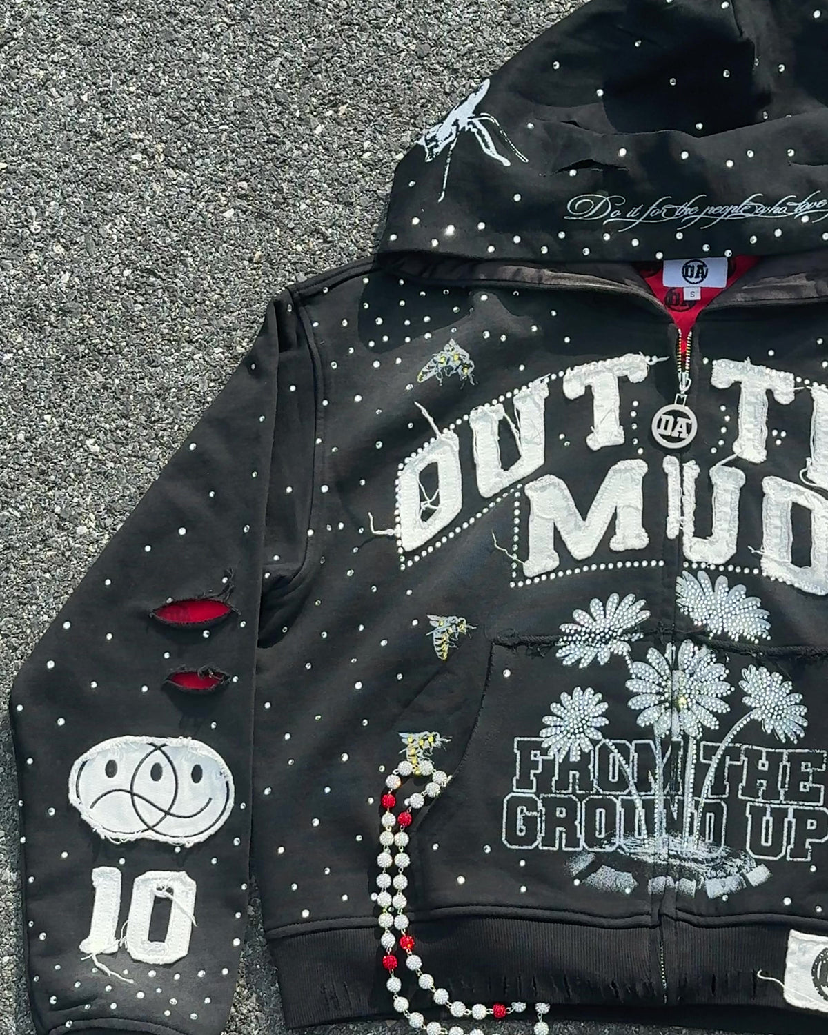 OUT THE MUD zip-up hoodie in black on the street with a bead chain