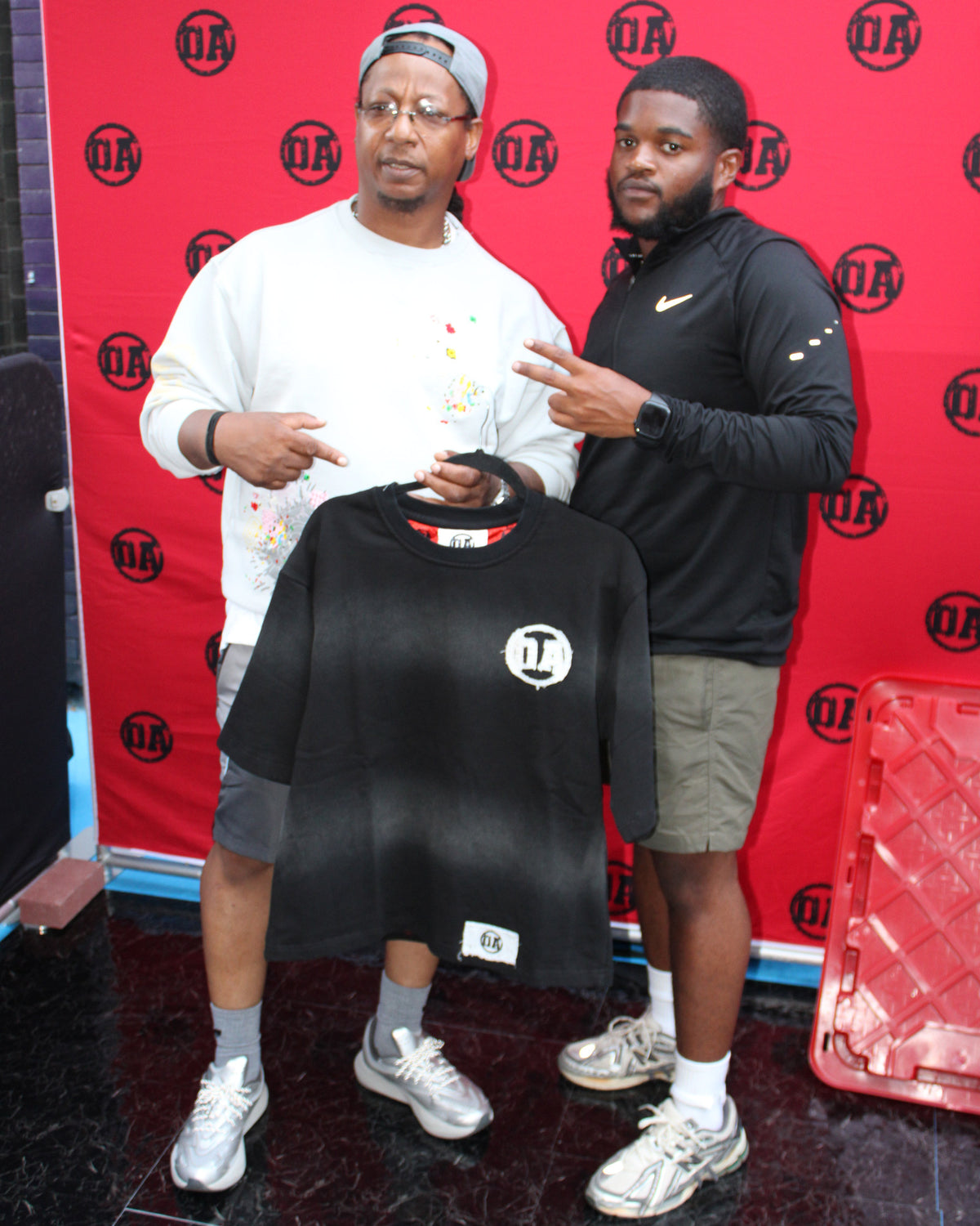 A customer holding the Origin Blank tee at the OA pop-up